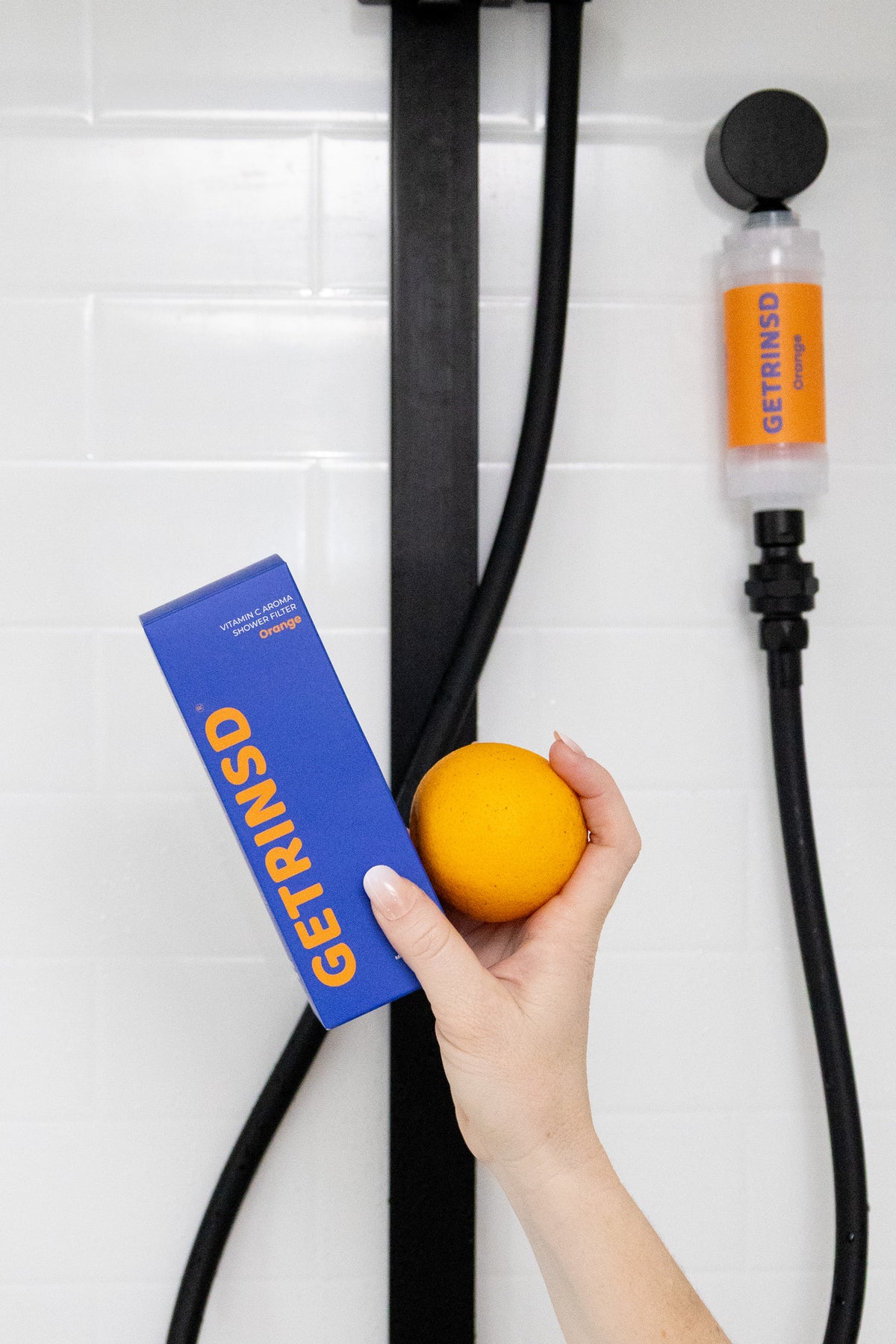 GETRINSD Vitamin C Aroma Shower Filter in orange with visible filter cartridge and packaging, designed for skin and hair care.